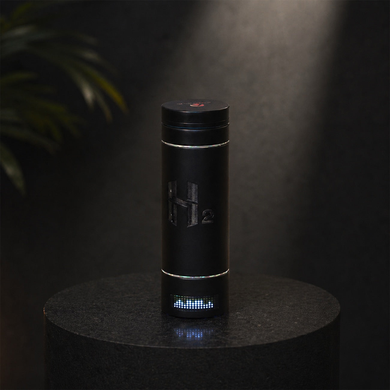 The HydroMax bottle in low light with its base charge indicator lit