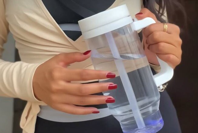 A woman holding the white HydroSipr by its handle