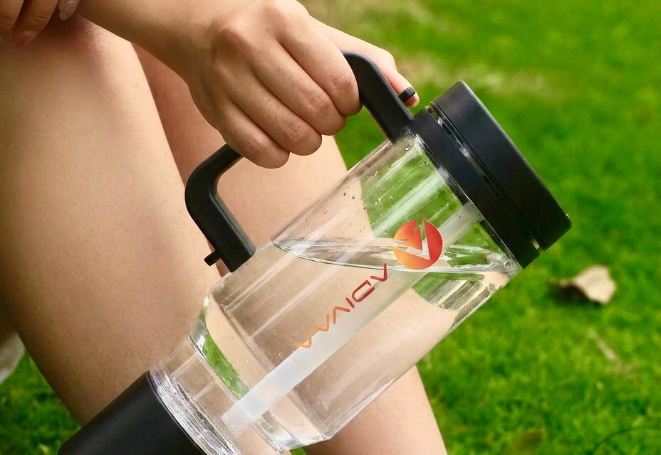 The black HydroSipr carried by its handle on the grass