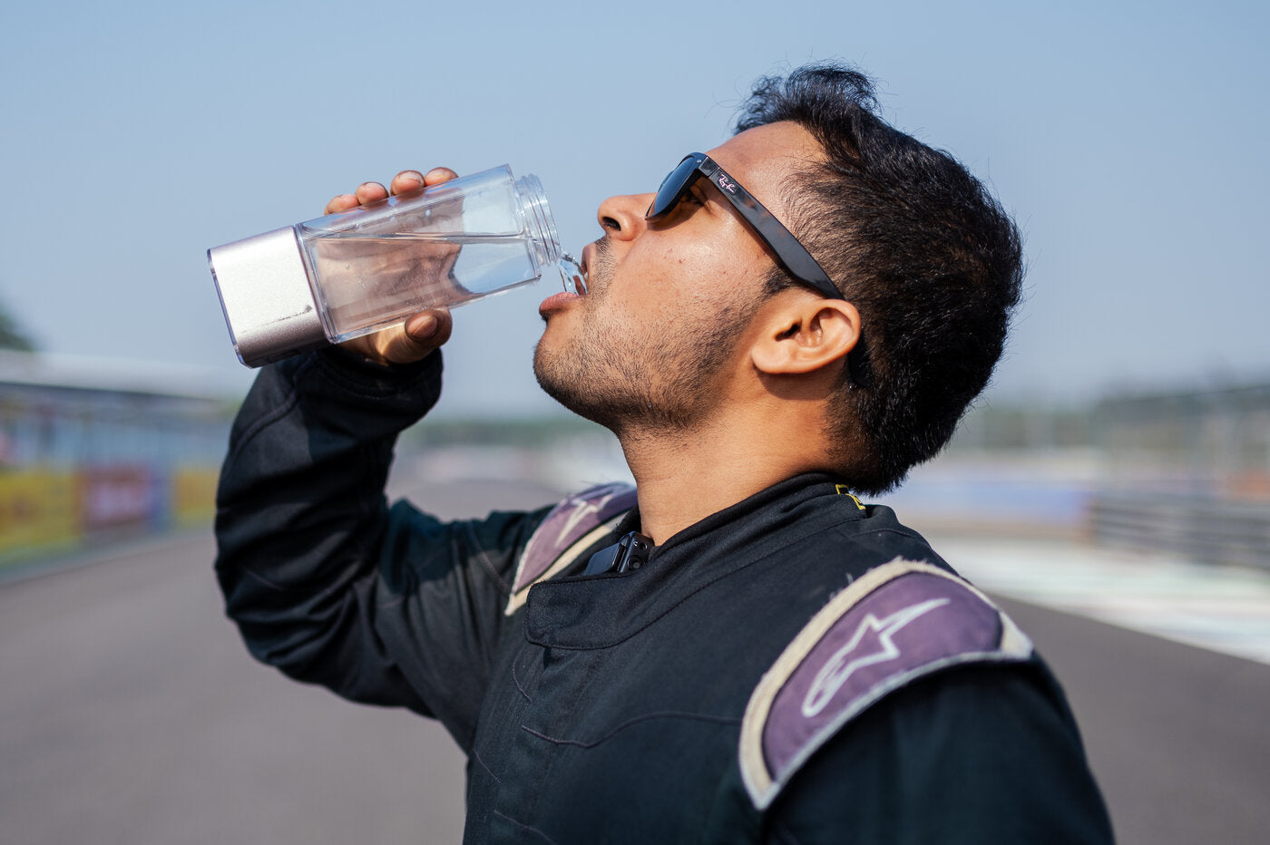 A racing driver drinking from the HydroUltra between sessions